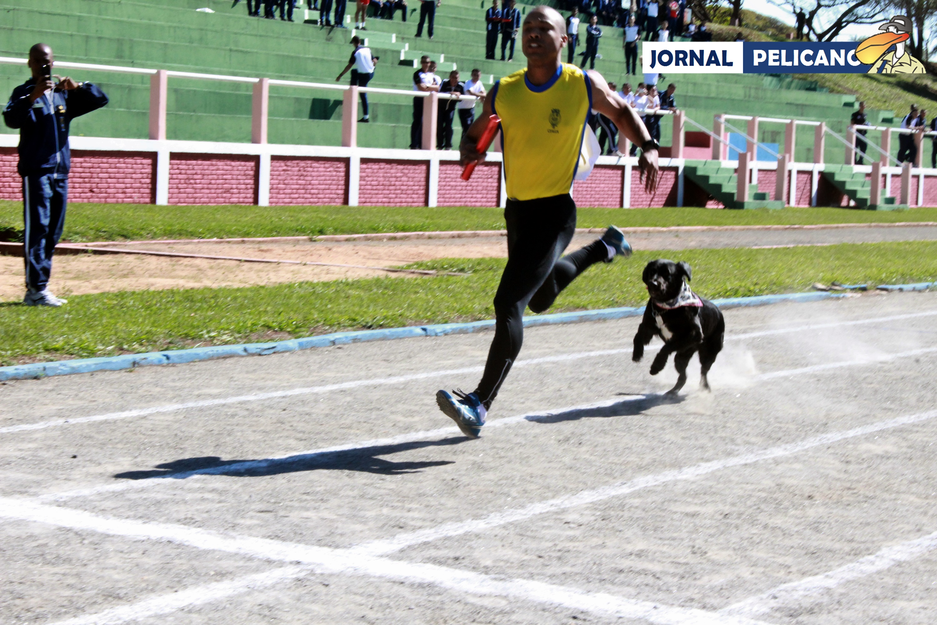 Al. De Souza da EFOMM corre ao lado da mascote do CIAGA Brisa, no revezamento 4x400. (Foto: Al. Sebastian / Jornal Pelicano)