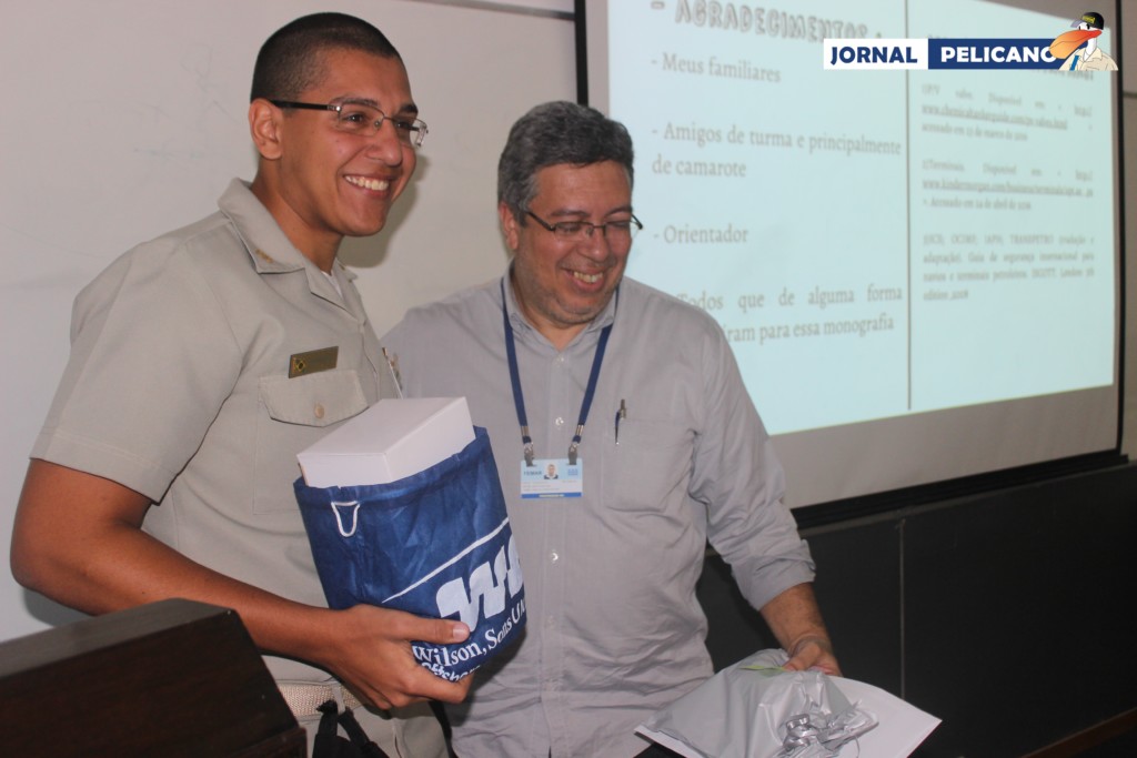 Aluno Perrotta recebe presente das mãos de seu orientador, professor Muniz. (Foto: Al. Fabrício / Jornal Pelicano)